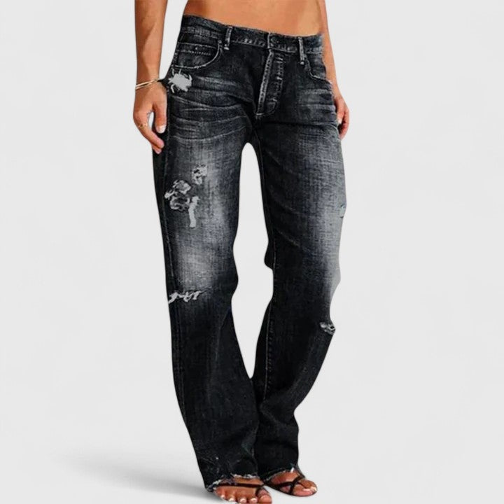 Jeans rasgados femininos de cintura baixa com corte largo. Tendência da moda casual para um visual despojado.