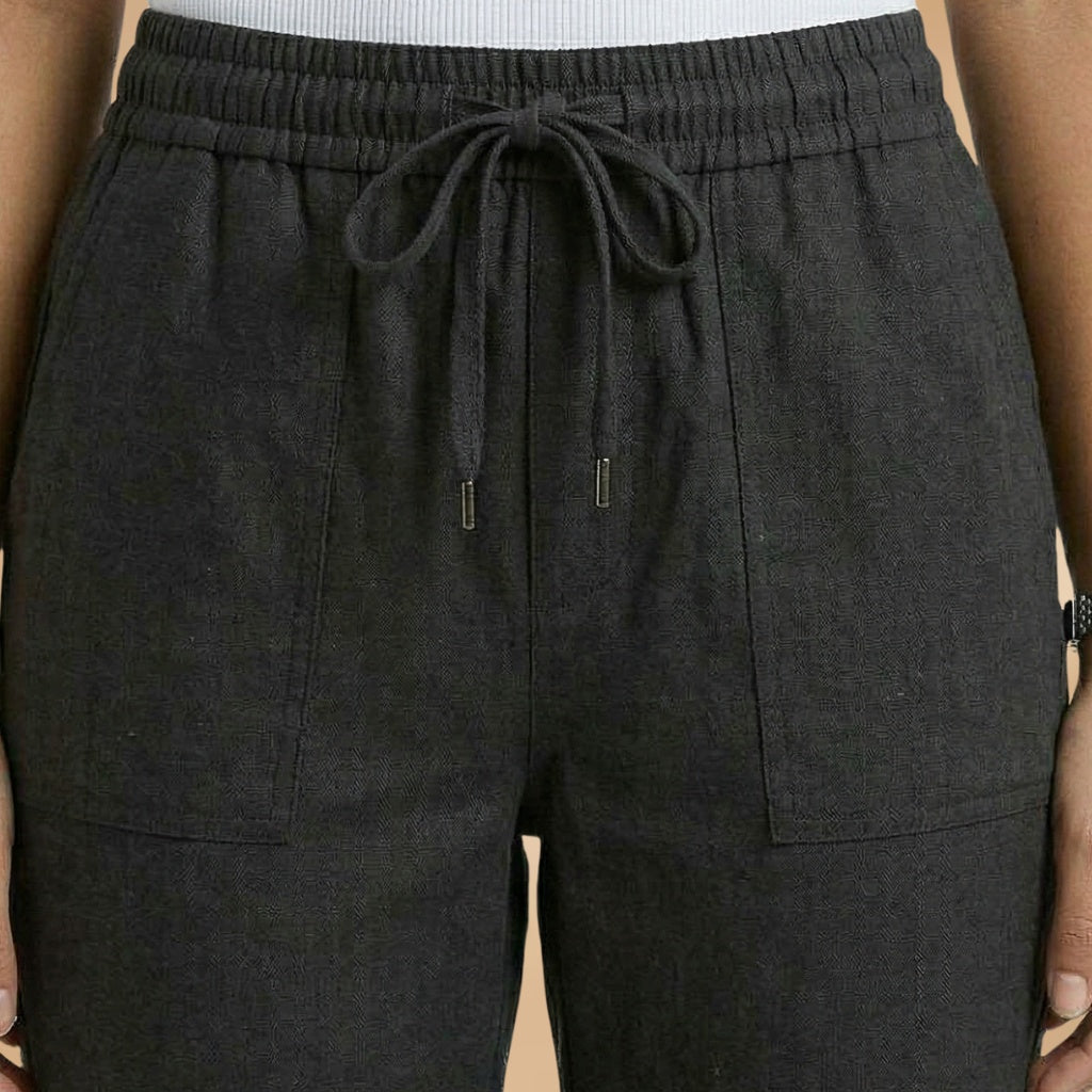 Calças de linho femininas em movimento, evidenciando o caimento fluido. Conforto e estilo para o dia a dia.
