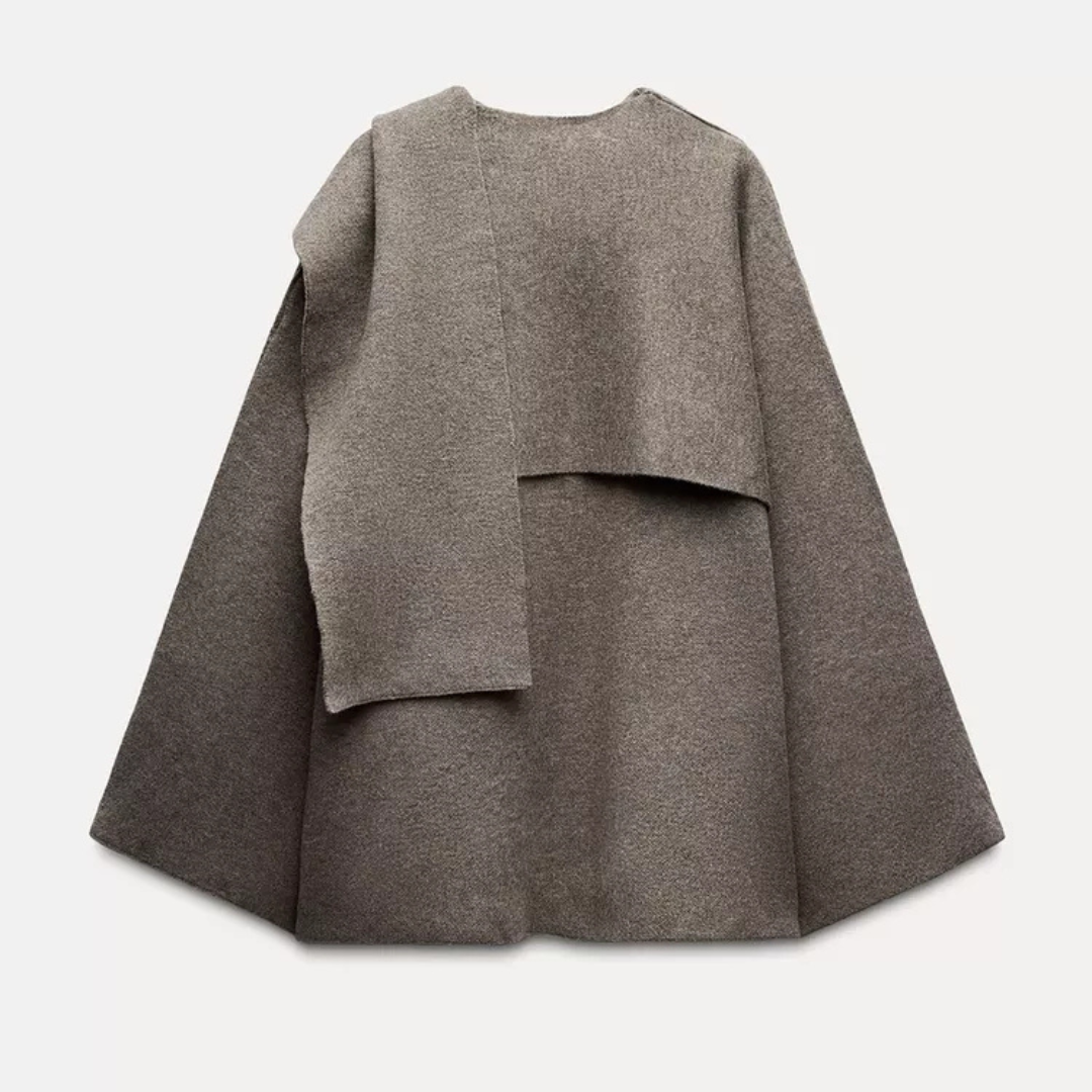 Poncho de lã confortável e assimétrico para mulher. Gola ampla proporciona aquecimento e estilo no inverno.