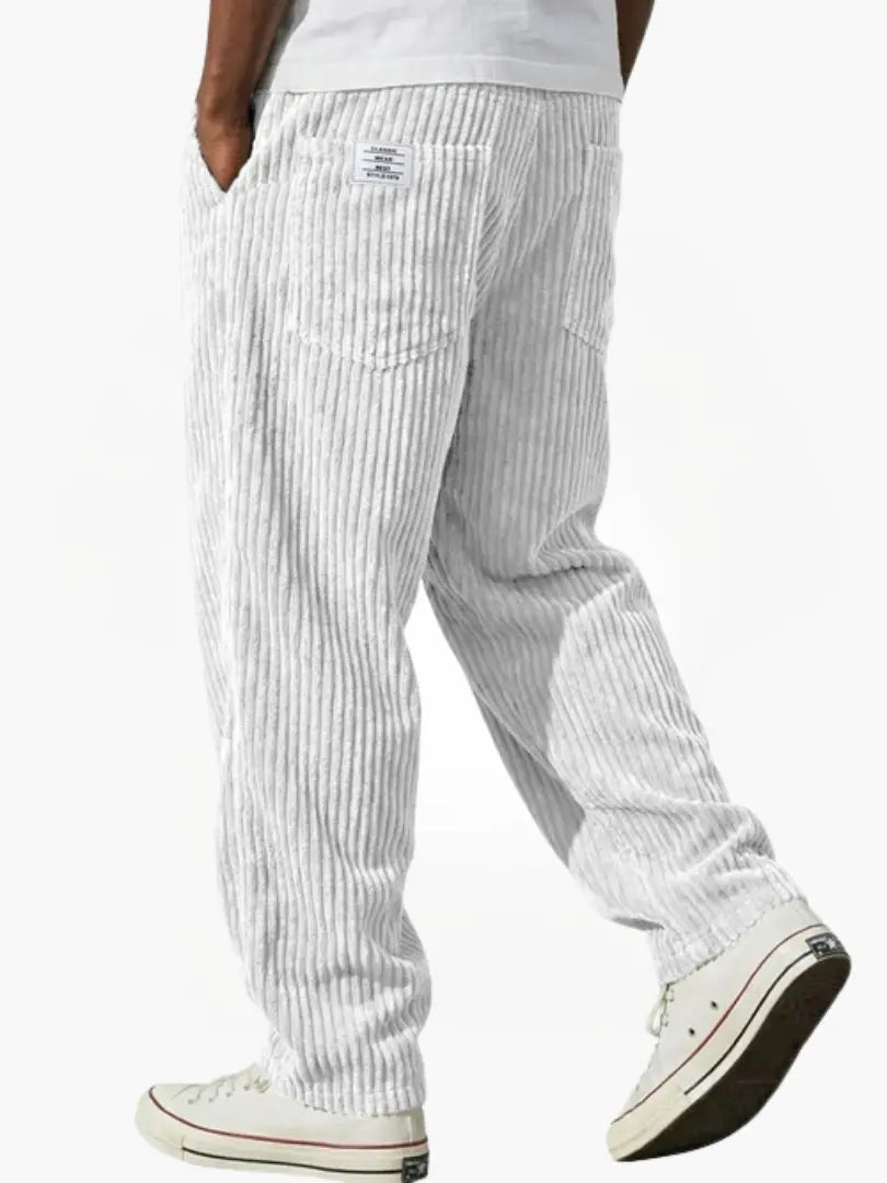 Detalhe das calças bombazine de homem, corte largo. Textura macia, conforto e estilo casual de inverno.