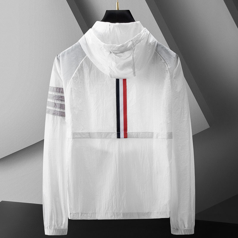 Homem veste corta-vento leve e desportivo com capuz e riscas. Roupa casual e funcional para exterior.