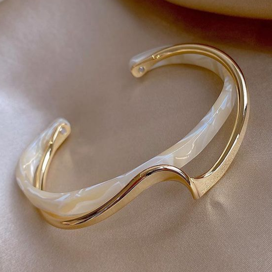 Pulseira feminina elegante dourada com opala branca, joia sofisticada e acessório luxuoso.