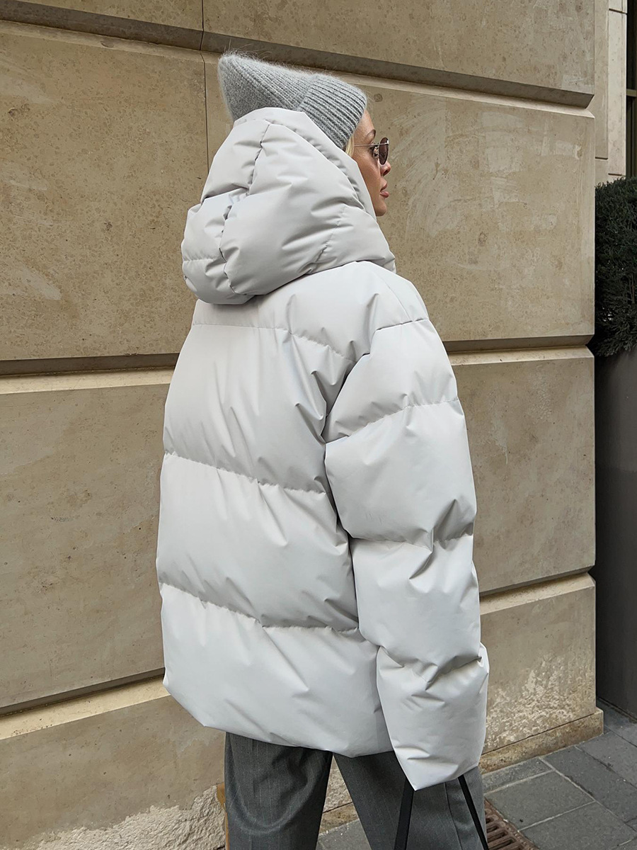 Modelo usando jaqueta acolchoada feminina com capuz no inverno, estilo casual e confortável.