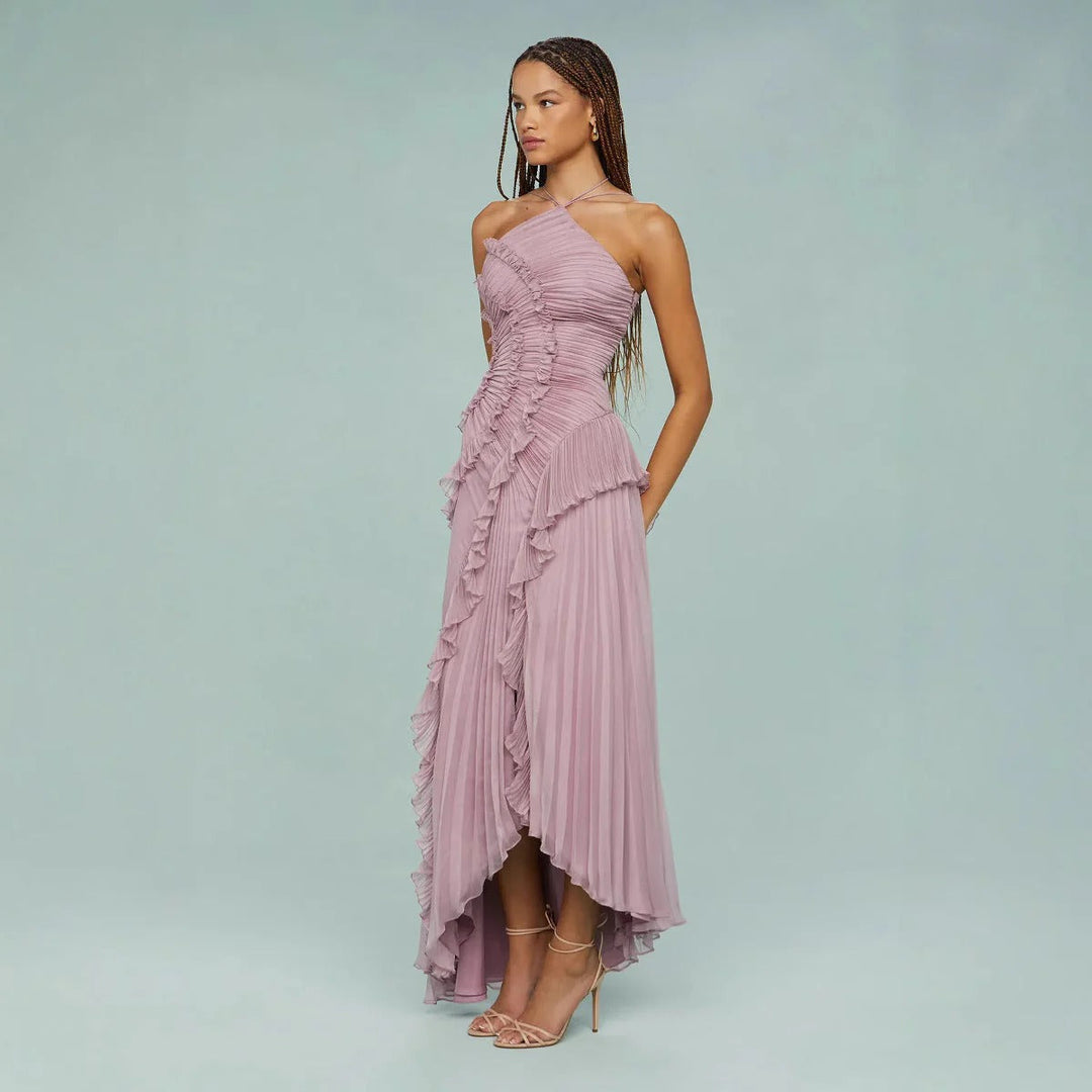 Vestido de festa formal com costas abertas, decote halter, babados e caimento longo.
