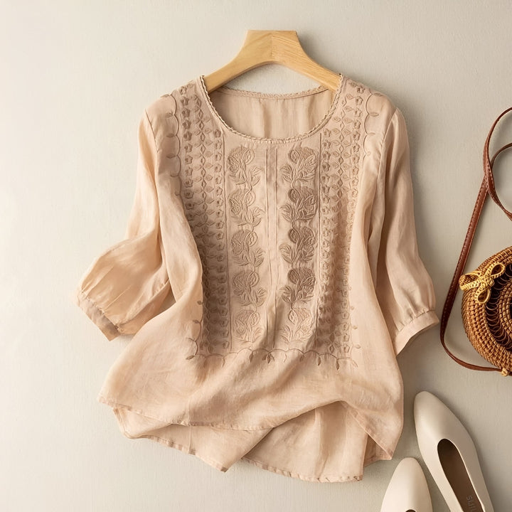 Blusa feminina solta branca com bordado floral delicado, ideal para looks casuais de primavera/verão. Confortável.