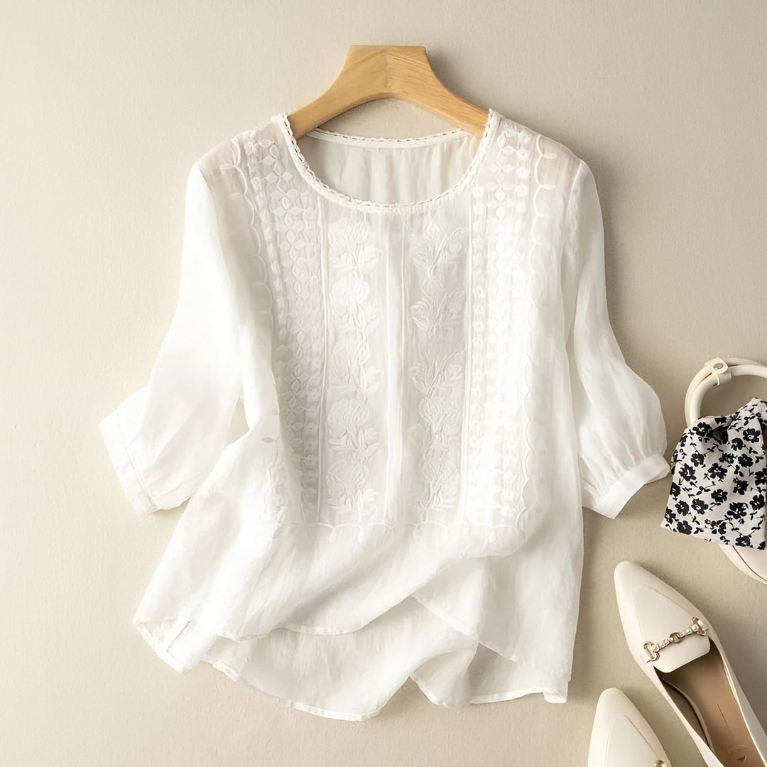Blusa feminina de verão com caimento solto e bordados florais sutis, perfeita para um estilo casual e elegante.