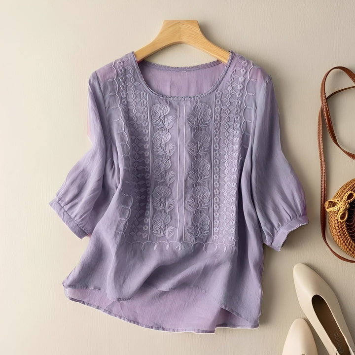 Modelo de blusa feminina casual solta, disponível em várias cores, destacando o bordado elegante. Confortável.