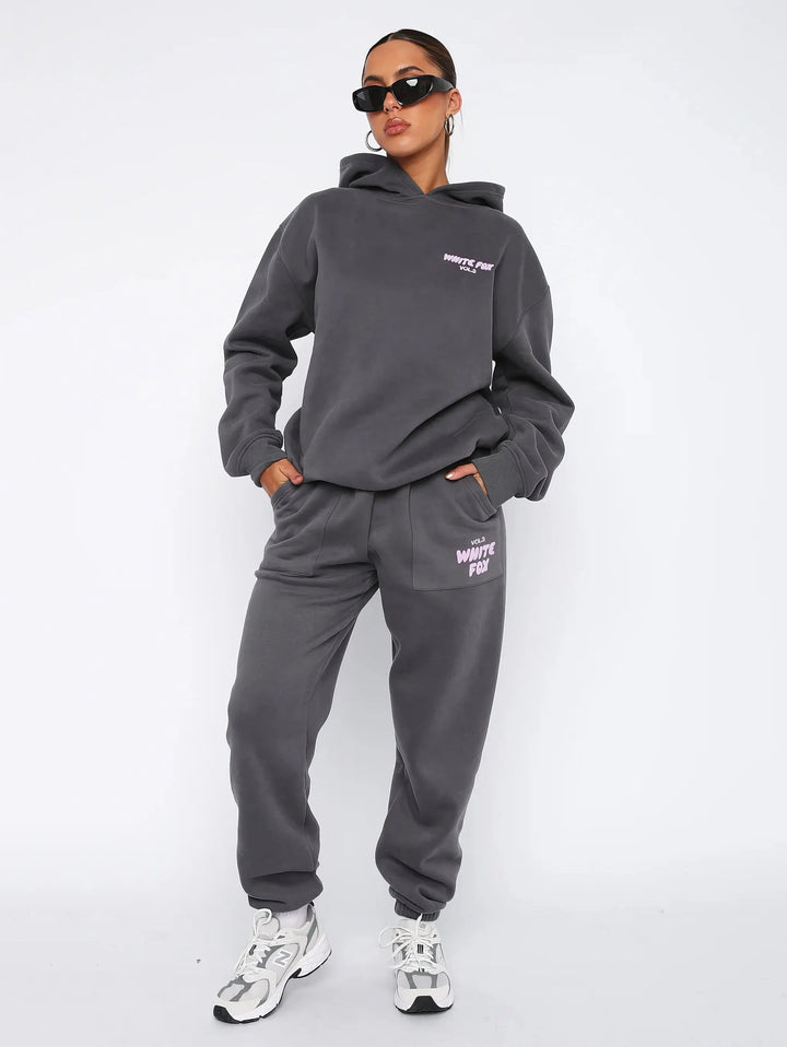 Roupa versátil para mulher: fato de treino oversized com hoodie e calças, perfeita para o dia a dia.