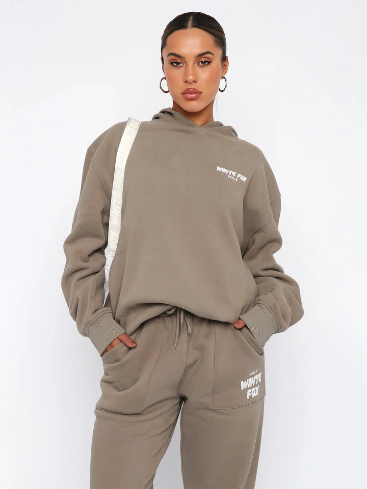 Fato de treino feminino versátil com hoodie e calças desportivas, para um estilo casual e moderno.