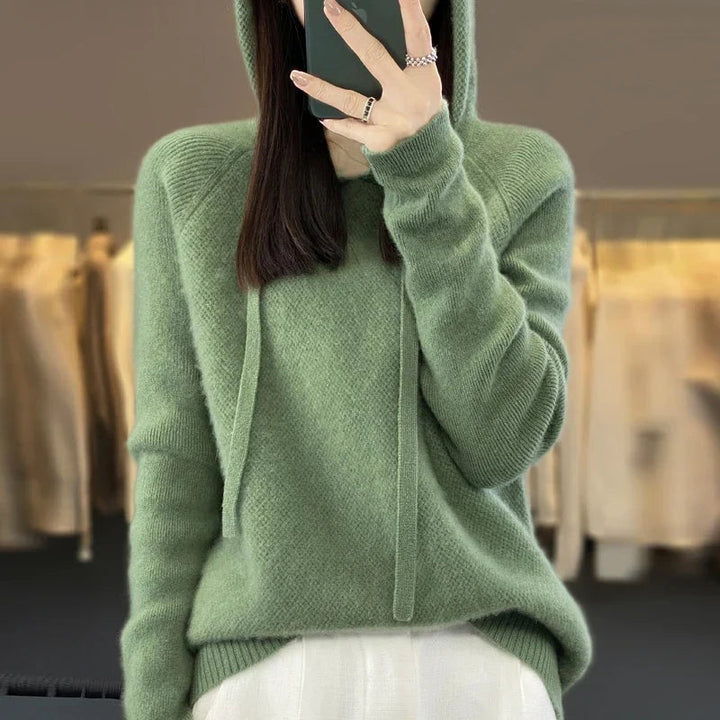 Detalhe da camisola de malha de lã merino para mulher, com capuz e caimento confortável e aconchegante.