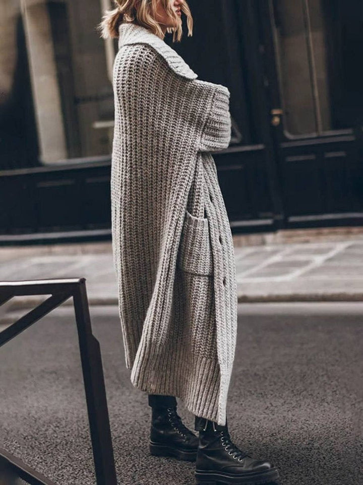 Cardigan oversize elegante feminino, em tricô longo com bolsos. Moda casual para outono/inverno.