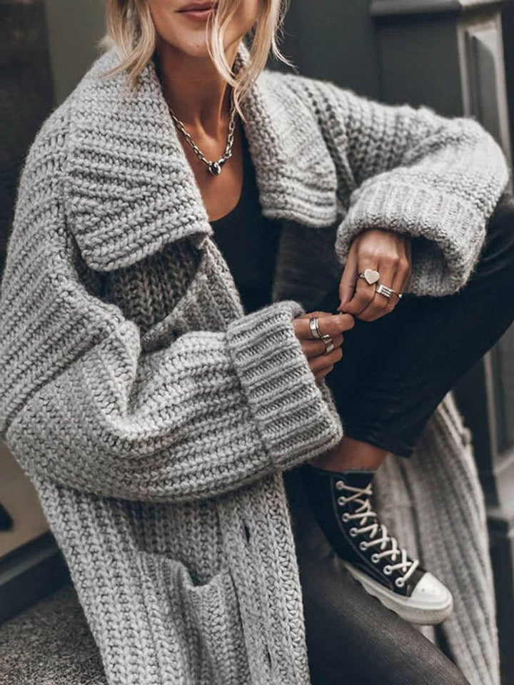 Cardigan longo feminino oversize de tricô com bolsos, ideal para um look casual e elegante no outono/inverno.