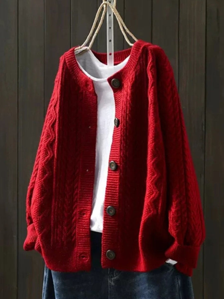 Detalhe do casaco feminino oversized de malha trança. Botões elegantes e textura acolhedora para o inverno.