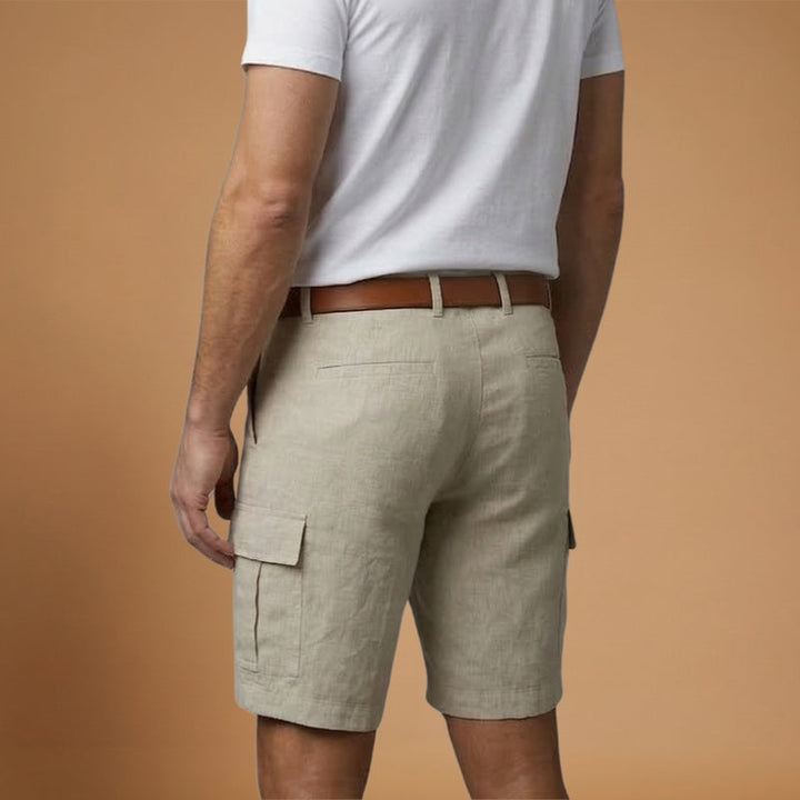 Modelo veste calções cargo de linho masculino, mostrando o caimento casual e moderno para o verão.