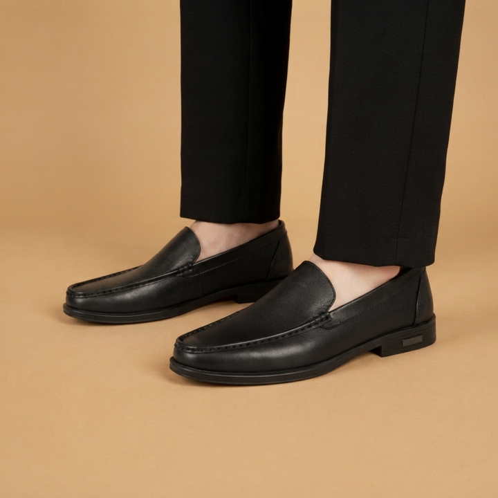 Homem usando mocassins slip-on de couro genuíno, calçado elegante e confortável para ocasiões sociais ou casuais.