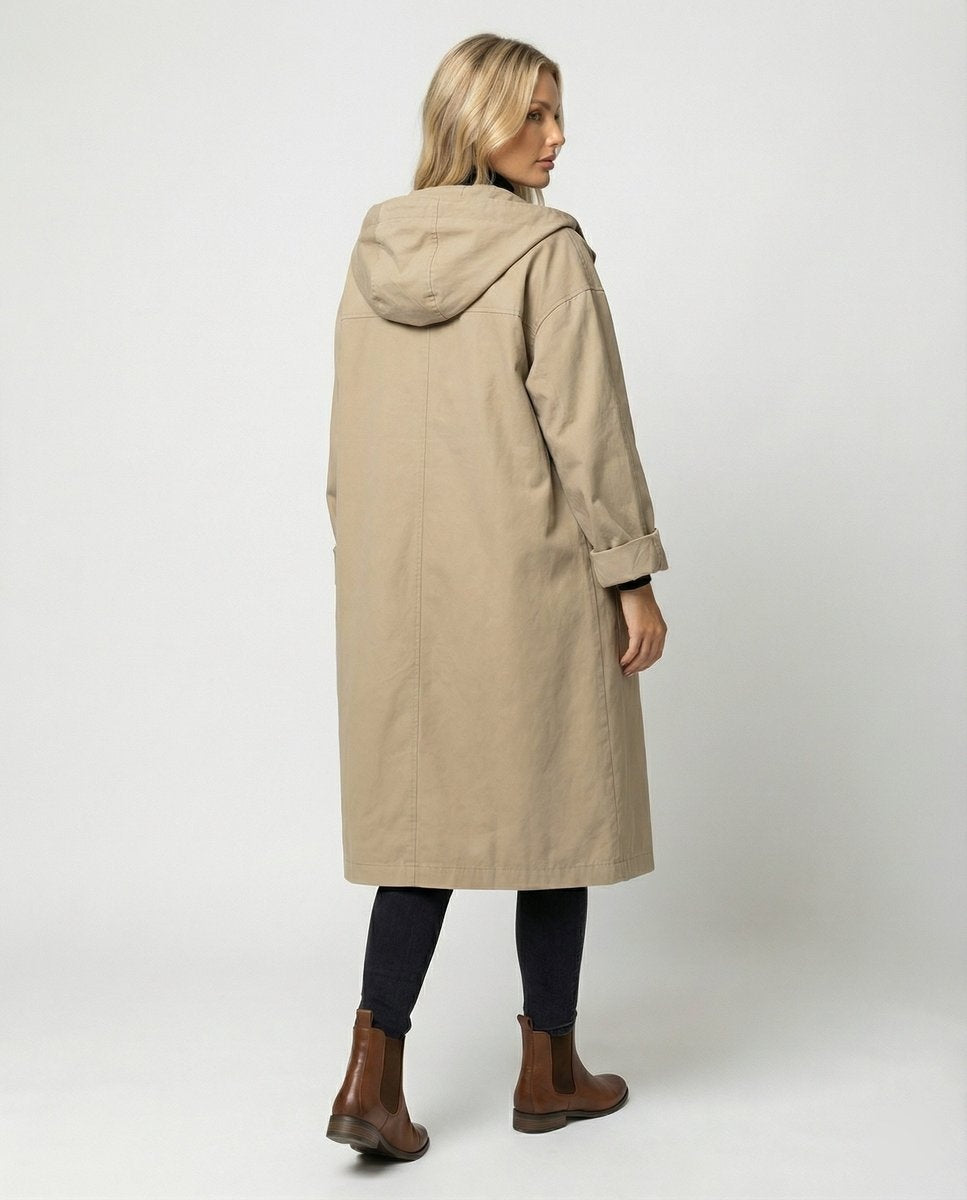 Mulher veste gabardina impermeável comprida com capuz, ideal para dias de chuva e frio de outono e inverno.