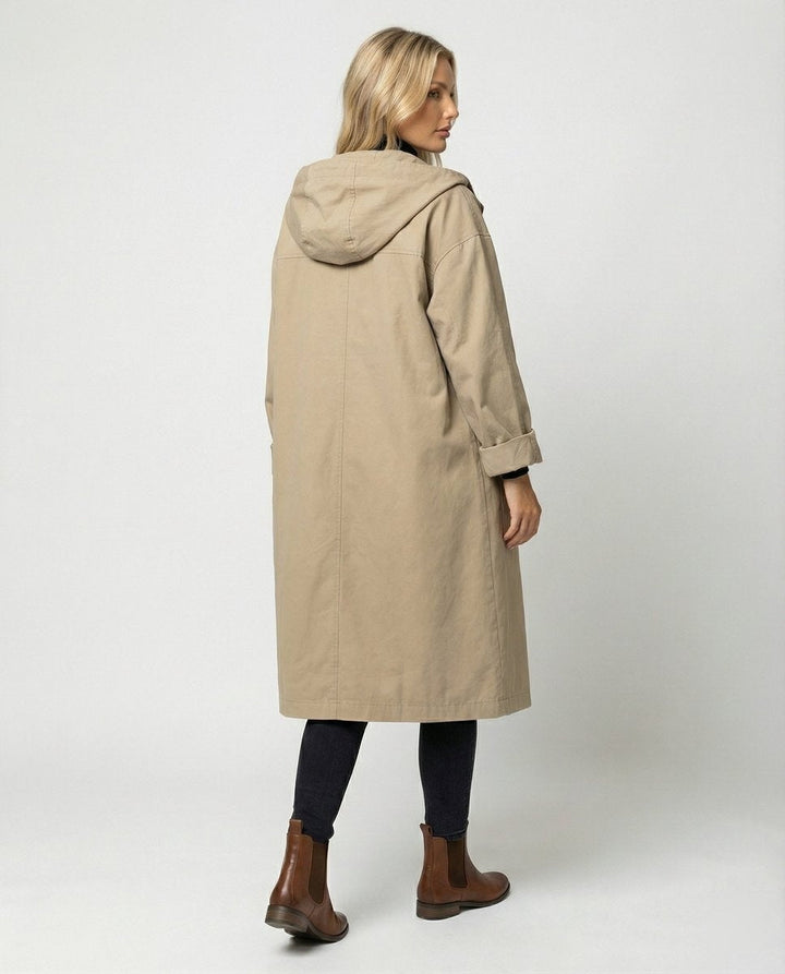 Mulher veste gabardina impermeável comprida com capuz, ideal para dias de chuva e frio de outono e inverno.