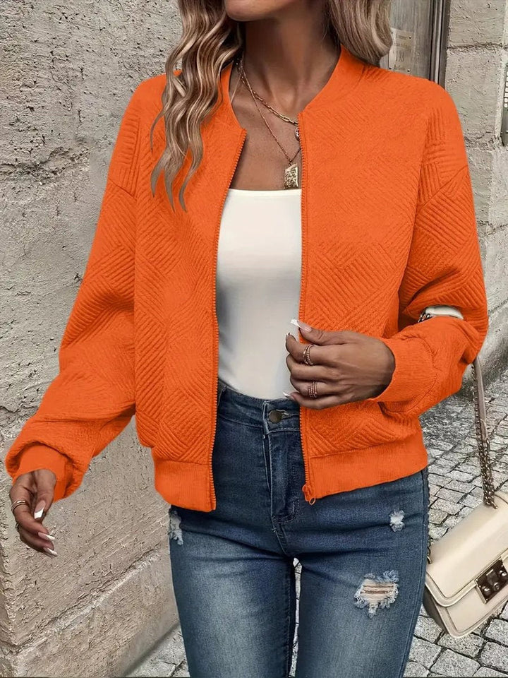 Detalhe do fecho zip no casaco bomber feminino, realçando a jaqueta moderna e o design.