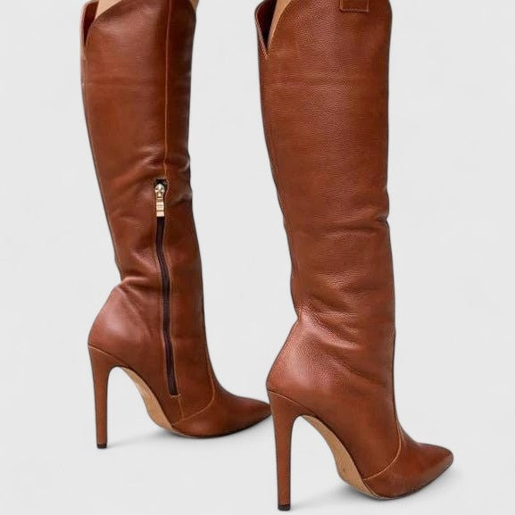 Botas de camurça cano alto para mulher, com biqueira pontiaguda e salto agulha alto, realçando a elegância e estilo.