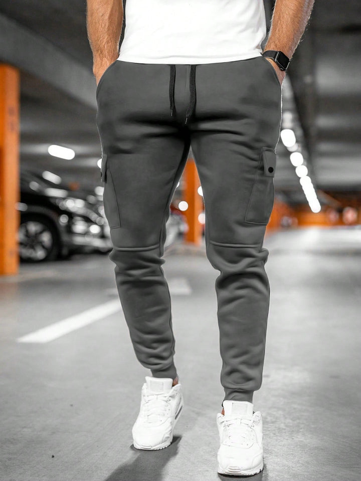 Calças cargo jogger masculina em sarja, múltiplos bolsos, punho elástico, ideal para conforto diário.