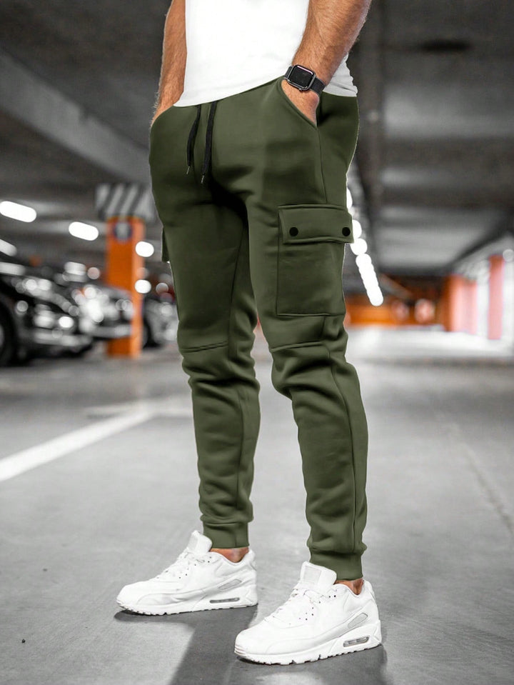 Detalhe da calça cargo jogger masculina: bolsos laterais espaçosos e punho na barra, moda urbana.