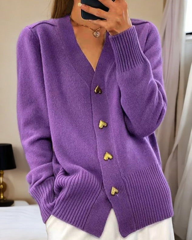 Detalhe do casaco de malha feminino com botões coração. Decote V, macio e confortável para os dias frios.