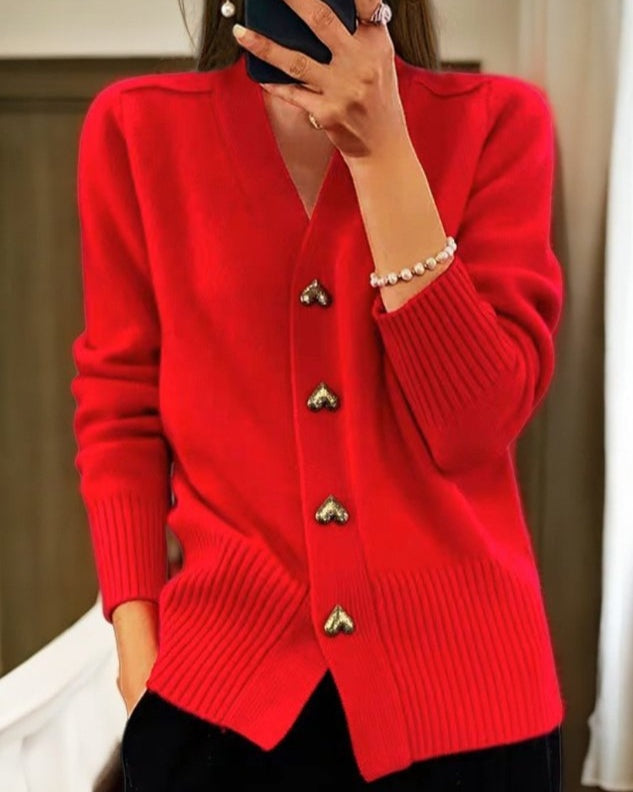 Mulher vestindo casaco de malha feminino com decote V e botões coração. Perfeito para um look de inverno.
