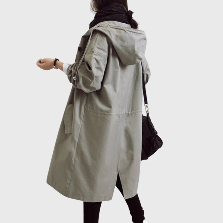Elegante gabardina feminina comprida impermeável, com capuz e corte largo, essencial para moda outono/inverno.
