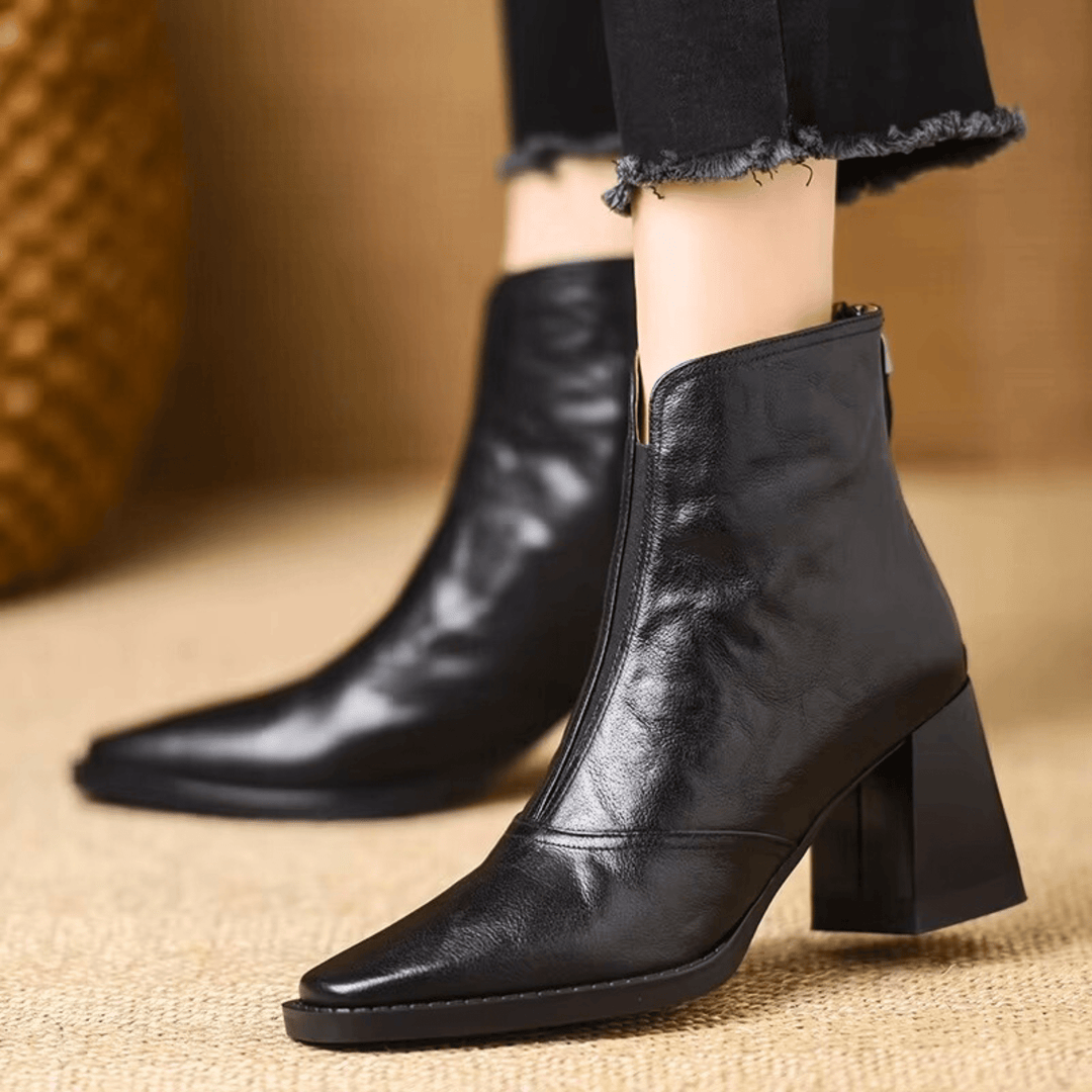 Silhueta de botins femininos pretos de tacão médio, perfeitos para elegância e conforto.