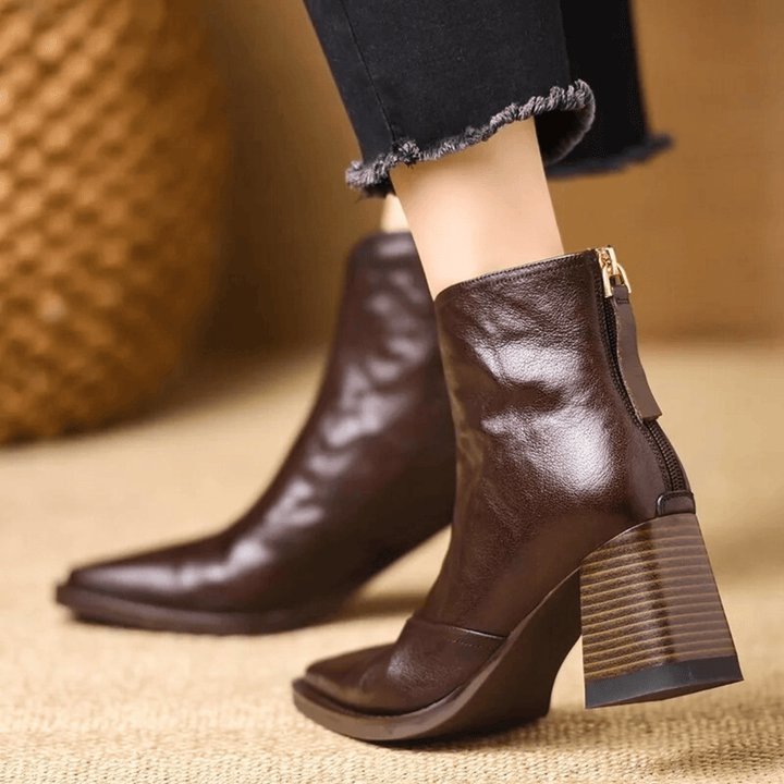 Mulher a usar botins femininos de tacão médio, calçado elegante e confortável de moda.