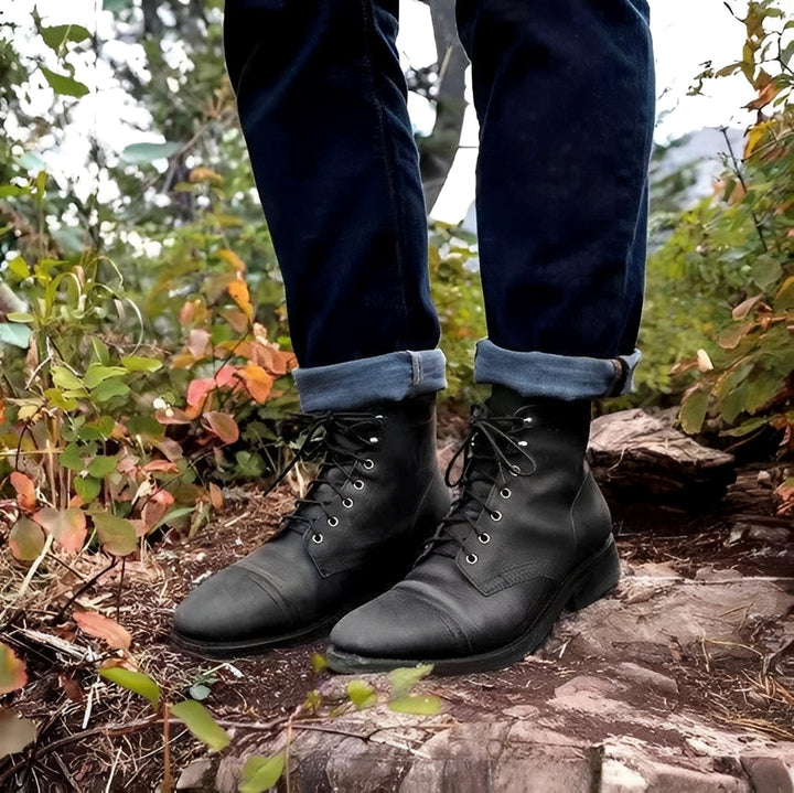 Detalhe das botas masculinas clássicas com cadarço, evidenciando o couro resistente e o design atemporal. Qualidade e conforto.